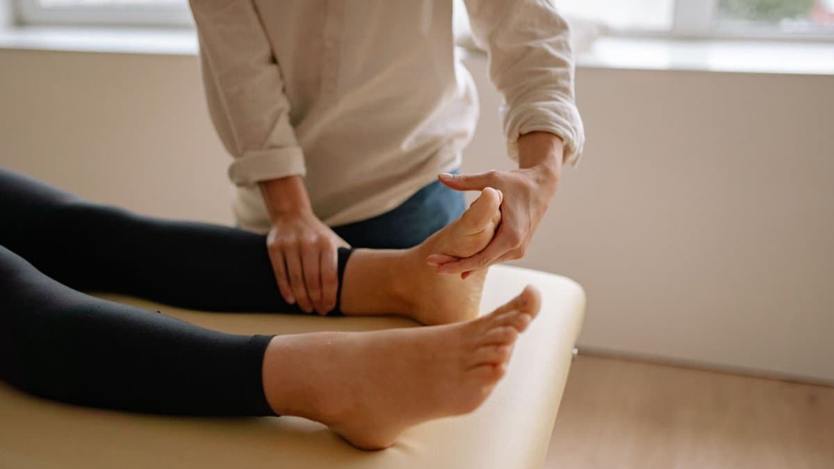Mouvement lent et enveloppant sur le pied d'une personne allongée sur la table