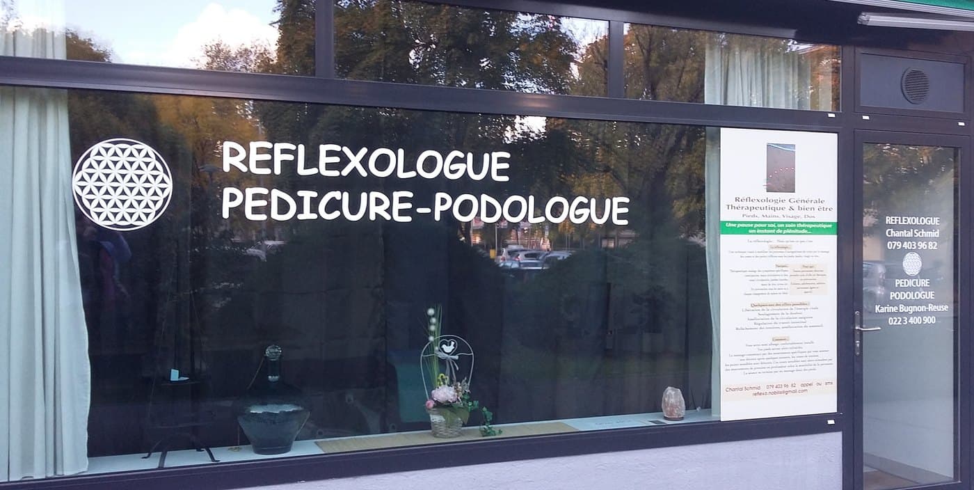 La vitrine du cabinet du Chemin des Sports 8 à Genève, marquée « Réflexologue » et ornée d'une Fleur de Vie