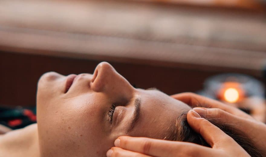 Mains posées sur les tempes lors d'un soin du visage